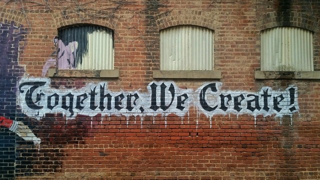 "Together we create" on brick wall